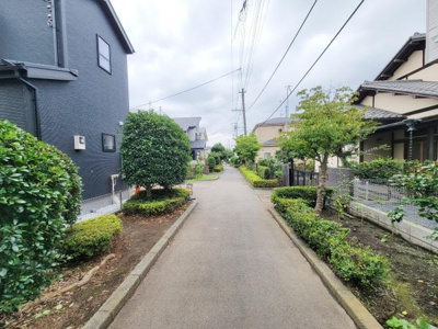 前面道路は幅が十分にあり落ち着いた雰囲気です。周囲は緑が多く手入れされた植栽が目を引きます。住宅街の中で車通りも少なく道も歩きやすい印象です。整然とした街並みが印象的です。