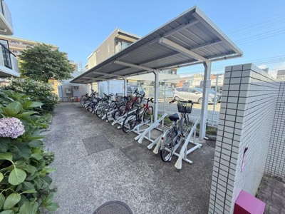 屋根付きの駐輪場が設置されており自転車の保管に便利です。整理されたスペースで複数台の駐輪が可能です。敷地内にはきれいな通路や緑もあり快適な環境です。出入りもスムーズに行えるよう設計されています。