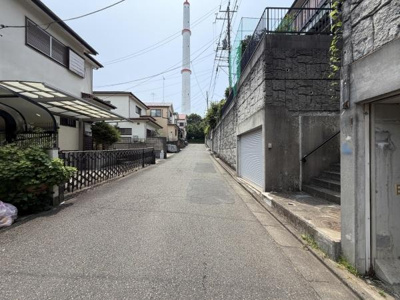 広々とした前面道路が特徴の現地写真です。周囲は住宅街となっており落ち着いた雰囲気が感じられます。道路の舗装も整備されており車の通行もスムーズです。