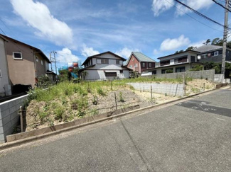 現地からは周辺住宅街の様子がよく見渡せます。前面道路は幅がしっかりと確保され車両の出入りもスムーズに行えます。写真からは現地の開放感や角地の特徴が伝わります。道路と土地の高低差も確認できます。