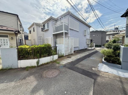 現地写真から周囲に住宅が建ち並ぶ落ち着いた街並みが感じられます。前面道路は車通りが少なく幅員も確保されています。敷地前には植栽が整えられており全体的に明るい雰囲気です。