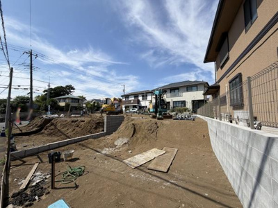 日当たりが期待できる現地土地写真です。前面道路との高低差があるためプライバシーも保ちやすい環境となります。建築プランの自由度も幅広く対応可能です。周辺には住宅が立ち並び落ち着いた雰囲気が感じられます。