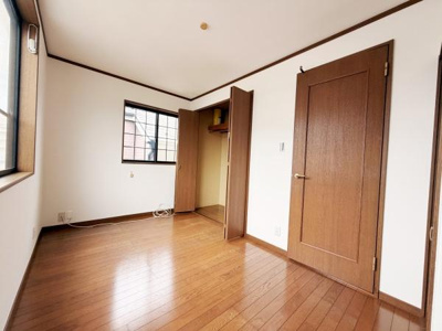 明るい窓から光が差し込む子供部屋です。クローゼット付きで収納も便利です。シンプルな内装でお手入れしやすいフローリング仕様です。扉や窓の枠には落ち着いた木目調が使われています。