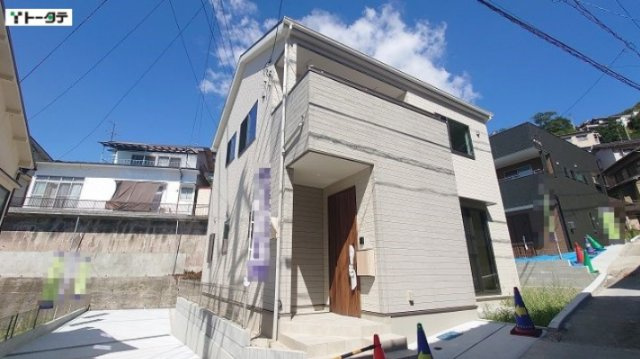全体的に落ち着いた色調の外観に、温かみのある木目調の玄関ドアが上品なアクセントを添えています。