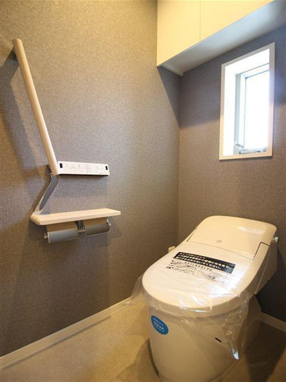 トイレ用品を収納できる棚付き。手すりあります。