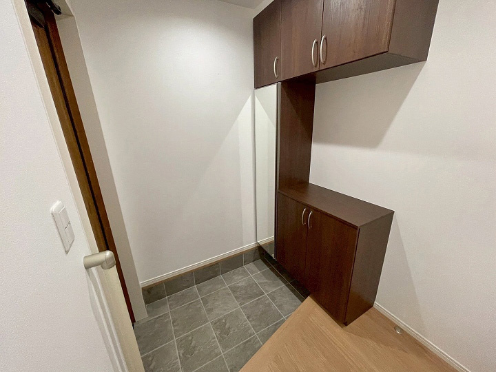 ダークブラウンの建具が落ち着いた雰囲気を演出する玄関。ご家族分の靴をたっぷり収納できる大容量のシューズボックスを完備。お出かけ前の身だしなみチェックに便利な全身鏡が備わっているのも嬉しいポイントです。