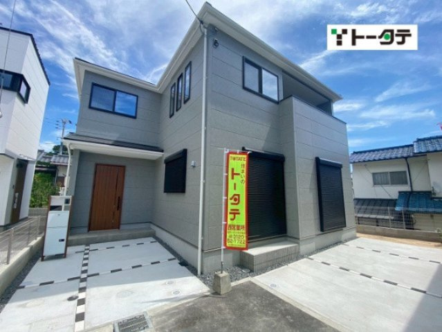グレーの外壁に木目調の玄関ドアがアクセント。駐車は複数台可能です。1階窓にはシャッター雨戸、2階にはバルコニーが設けられています。