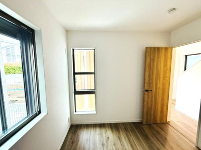 明るさを感じる室内で窓からの自然光が心地よく広がります。シンプルなデザインと木目調の床が特徴的です。無駄のないシンプルな空間が広がっています。木製ドアが空間に温かみを与えています。