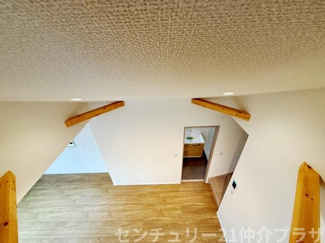 天井近くに設けられた梁がアクセントになっている空間です。壁や床の色味が統一され落ち着いた雰囲気が広がります。部屋の奥には別の空間が繋がっており使い勝手の良さが伺えます。開放感を感じられる仕様です。