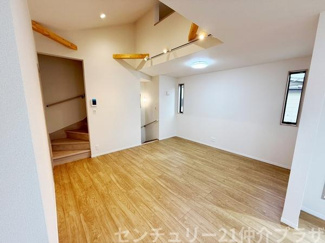 開放感のあるリビングは木目調の床が空間に温かみを与えています。吹抜け部分から自然光が入りやすい設計です。照明や窓の配置で明るさを確保しやすいです。階段スペースとのつながりもありすっきりした印象です。