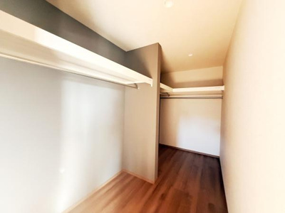 広々とした収納スペースがあり片付けや整理整頓がしやすい設計です。天井も高くハンガーパイプが複数設置されています。奥行きがありたっぷりと季節物の収納にも対応できます。