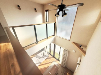 吹き抜けの空間が開放感を演出しています。大きな窓からたっぷりと光が差し込む明るい室内です。室内の風通しにも配慮されています。シーリングファンが設置され快適に過ごせます。眺望も楽しめる作りです。