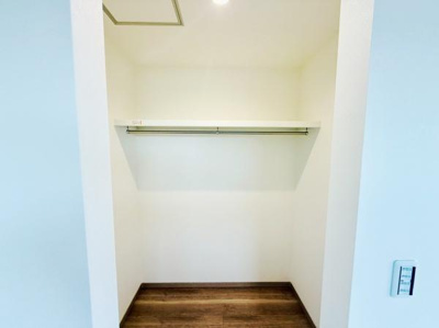収納スペースがしっかり確保されています。シンプルで使いやすい内装です。白を基調とした空間が明るい印象を与えます。棚とハンガーパイプが備わっています。床の色合いが落ち着きを感じさせます。