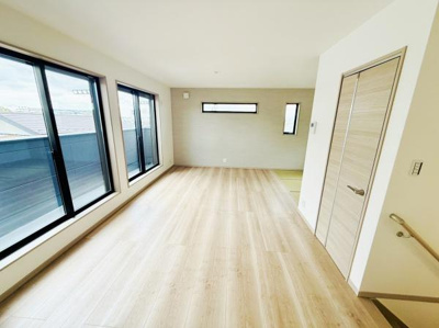 大きな窓からたっぷりと光が差し込む明るいリビングです。フローリングの色合いが空間を広く見せてくれます。壁面にはモダンな小窓が設けられており通風や採光にも配慮されています。