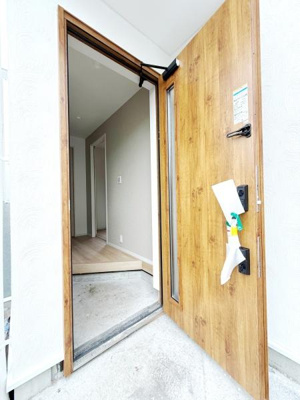 木目調の玄関ドアが印象的で温かみのある雰囲気を感じられます。ドアのサイドガラスからはやさしい光が入ります。室内へ自然につながる開放的なエントランスが魅力です。