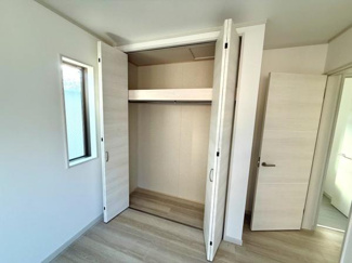 大きな開口の収納スペースがあり整理整頓しやすい造りです。扉は開閉がしやすく室内の動線も確保されています。棚も設置されているため使い勝手が良い収納です。明るい内装が室内の印象を引き立てています。