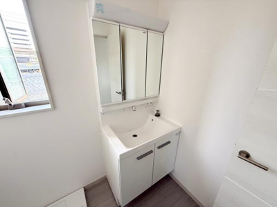 明るい採光が入る洗面所ですっきりとしたデザインが特徴です。収納スペースも備わっており日常使いに便利です。洗面台は清潔感のあるホワイトカラーとなっています。室内全体がシンプルで使いやすい雰囲気です。