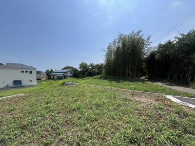 陽当たりの良い現地土地写真です。周囲には緑が多く開放感が感じられます。道路も近くアクセスしやすい立地となっています。周辺には住宅もあり静かな環境が広がっています。建築の際にも使いやすい整った地形です。