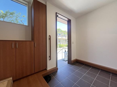 明るい採光の玄関スペースが広がっています。シューズボックスが壁面に設置されており収納力も十分です。玄関ドアは採光スリット付きで自然光が差し込みます。床はタイル仕上げでお手入れもしやすい仕様です。