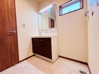 シンプルなデザインの洗面台が設置されています。明るい空間で毎日の身支度も快適です。収納スペースも備えられているため使い勝手にも配慮されています。小窓からの採光があり清潔感が感じられます。