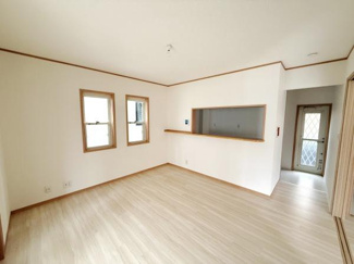 二つの窓から光が差し込み明るさが感じられるリビングです。キッチンとのつながりも良好で広さが確保されています。ナチュラルなフローリングと白い壁が空間をすっきり見せています。