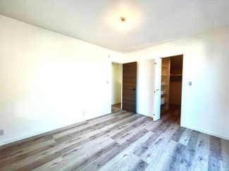 明るい色合いのフローリングが特徴の洋室です。収納スペースも備わっており室内は整理しやすくなっています。壁面が広くインテリアの配置もしやすい空間です。開放感のある室内は使い勝手が良いです。