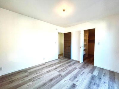 明るい色合いのフローリングが特徴の洋室です。収納スペースも備わっており室内は整理しやすくなっています。壁面が広くインテリアの配置もしやすい空間です。開放感のある室内は使い勝手が良いです。