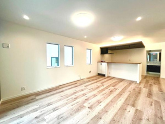 明るい色調の床材が全体をすっきりと見せています。3つの窓がしっかりとした採光を確保しています。カウンターキッチンがリビングとの一体感を演出します。