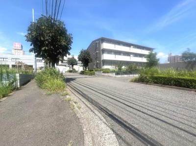 前面道路は幅が広く見通しの良い環境となっています。周辺には緑も点在しゆったりとした雰囲気が感じられます。舗装された歩道が整備されており利用しやすい印象です。周囲に高い建物が少なく開放感があります。