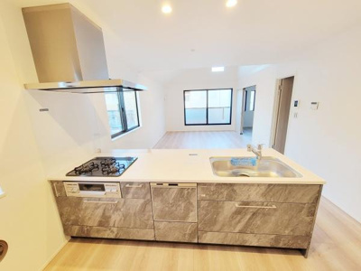 広々としたキッチンで作業スペースもたっぷり確保されています。収納も充実しており効率的に使えます。シンプルで明るい内装が特徴です。リビングと一体感のあるデザインです。