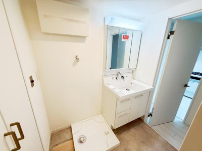 明るい空間に設置された洗面台は収納スペースも豊富で使い勝手が良い仕様です。洗濯機置き場が近く動線にも配慮されています。清潔感のある内装でメンテナンスも簡単です。広々とした空間設計が特徴です。