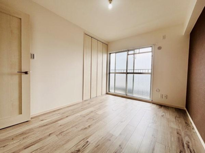 明るい陽射しが差し込む洋室です。床の木目調が空間を引き締めています。クローゼットが設置されており整理に便利です。窓が大きく開放的な印象を持たせています。