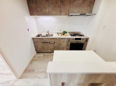 シンプルで使いやすいレイアウトのキッチンです。収納スペースが豊富で調理器具の整理もスムーズに行えます。換気扇やコンロも設置されており機能性を重視した空間です。