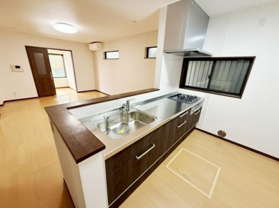 開放感のある対面式キッチンで室内全体が見渡しやすい設計です。広めのカウンターで作業も快適に行えます。窓付きで明るい空間が広がっています。収納スペースも充実しています。