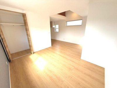 リビングは2面採光で明るさをしっかり感じる空間です。バルコニーへのアクセスもスムーズです。シンプルな内装で好みに合わせてコーディネートできます。白を基調とした床が開放感を演出しています。