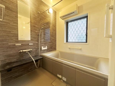 落ち着いた色合いの壁面が洗練された雰囲気を演出しています。大きめの窓があり明るい空間になっています。浴槽はゆったりとしたサイズ感で使いやすいです。