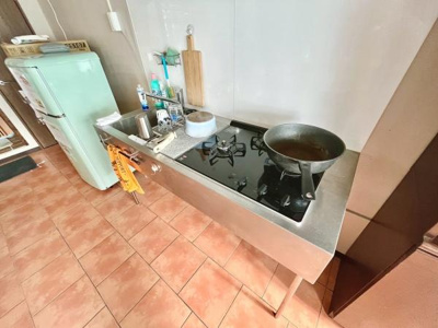 シンプルなデザインのキッチンでお手入れがしやすいステンレス仕様です。ガスコンロが設置されており調理スペースも確保されています。冷蔵庫も備え付けられておりすぐに使える環境です。