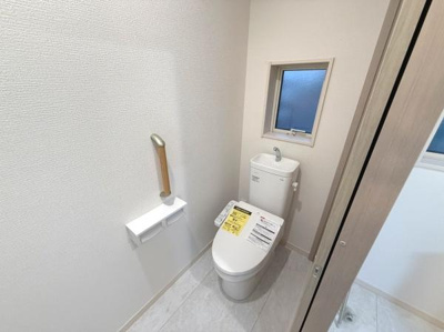 清潔感のあるトイレ空間です。手すりが設置されていて使い勝手に配慮されています。窓付きで換気しやすいのが特徴です。床や壁のカラーリングが明るく気持ちよくご利用いただけます。