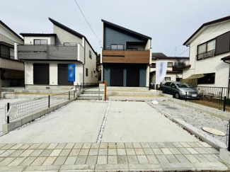 建物のデザインが印象的な現地写真です。駐車スペースが広く車の出し入れもスムーズに行えます。周辺の住宅とも調和した落ち着いた雰囲気が感じられます。前面道路までのアプローチも整備されています。