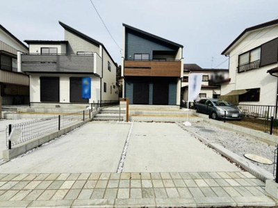 建物のデザインが印象的な現地写真です。駐車スペースが広く車の出し入れもスムーズに行えます。周辺の住宅とも調和した落ち着いた雰囲気が感じられます。前面道路までのアプローチも整備されています。