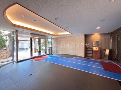 広々としたエントランスが開放感を演出しています。天井の照明が全体を明るく照らし清潔感のある空間です。大きなガラス扉が自然光をしっかり取り込みます。来客時にも安心の印象を与える設計です。