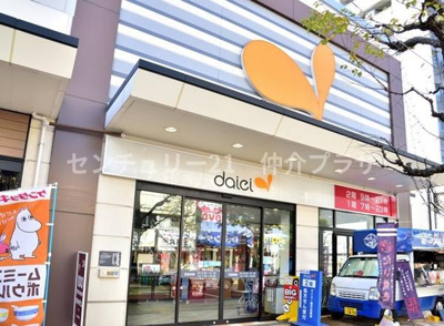 店舗前には分かりやすいロゴがあり目を引く外観です。ガラス扉で店内の様子も確認しやすい入口です。自動車や自転車での来店にも対応したスペースが設けられています。右手には移動販売車も確認できます。