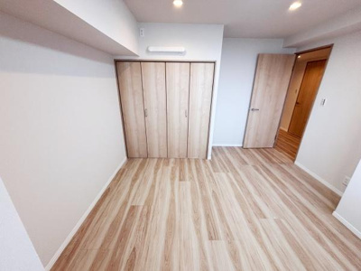 ナチュラルな色合いの床材が明るい印象を与えます。クローゼット扉も統一感のあるデザインです。天井までしっかり照明が届き圧迫感がありません。シンプルな内装なので家具の配置がしやすいです。