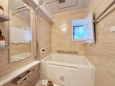 清潔感のある壁面デザインが特徴のバスルームです。窓付きで日中の換気がしやすくカビ対策にも役立ちます。浴槽はゆったりとしたサイズ感で快適な入浴を実現します。