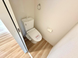 明るい色味のフローリングが特徴的なトイレです。手洗い付きタンクが設置されており機能的な空間になっています。壁面も清潔感がありお手入れもしやすい印象です。