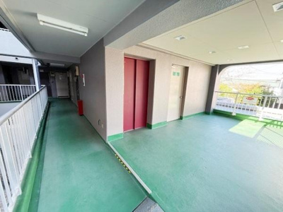 エントランス付近の開放的な共用スペースです。エレベーターが設置されており移動がスムーズです。外光が差し込む明るい空間となっています。手すり付きの歩道で安心して通行できます。