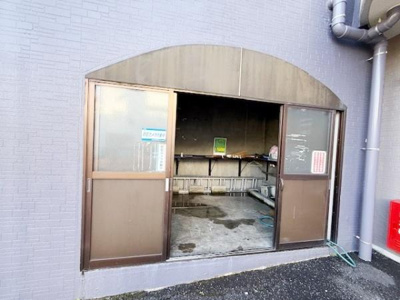 建物の外壁に隣接した専用スペースです。広々とした開口部で利用しやすい設計となっています。扉がしっかりと設けられ内部も整理されている印象です。使用時の出入りがしやすい立地も魅力のひとつです。