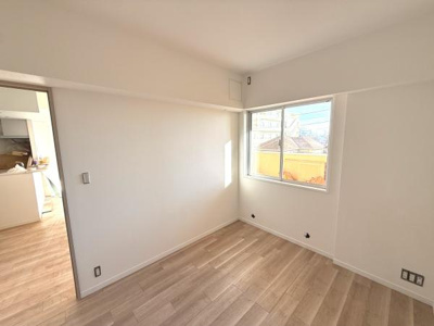 洋室には明るい陽射しが差し込みすっきりとした印象です。ナチュラルな色合いのフローリングが空間を落ち着いた雰囲気にしています。シンプルな内装で多様なインテリアにも調和しやすいです。