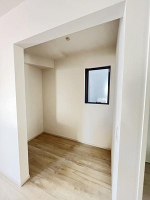 シンプルなデザインの収納スペースです。明るい色合いのフローリングで清潔感があります。奥行きがしっかり確保されています。窓から自然光が入り圧迫感を感じにくい空間です。