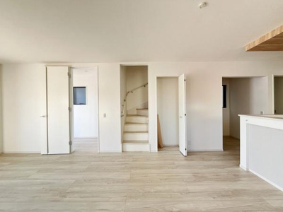 リビングは明るく開放感があります。シンプルなデザインで家具の配置がしやすい設計です。隣接する階段や各部屋への動線がスムーズです。木目調の床が空間に温かみをプラスします。無駄のない間取りが印象的です。